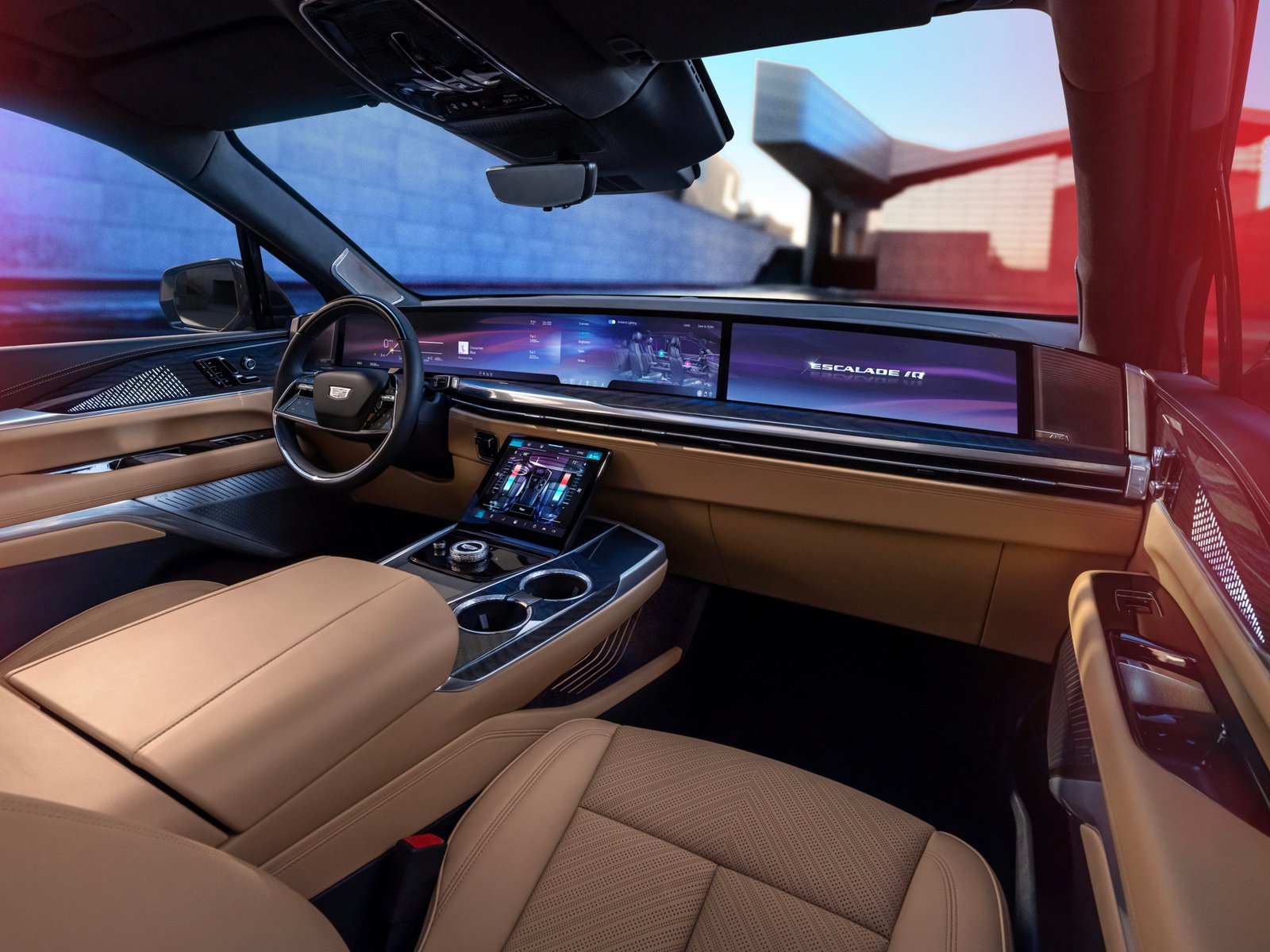 View of front seats, steering wheel and pillar-to-pillar screen in Cadillac ESCALADE IQ Sport.